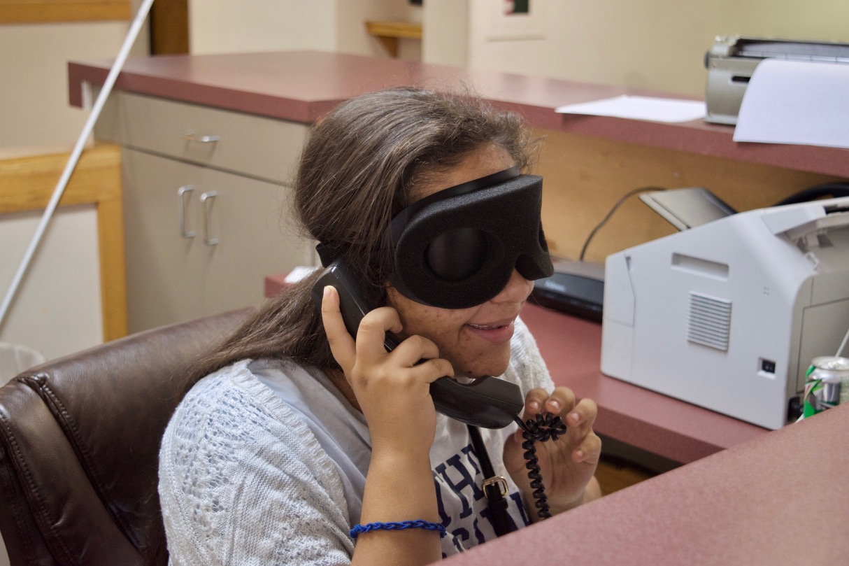 Luisa takes a phone call at the Front Desk at the Colorado Center for the Blind
