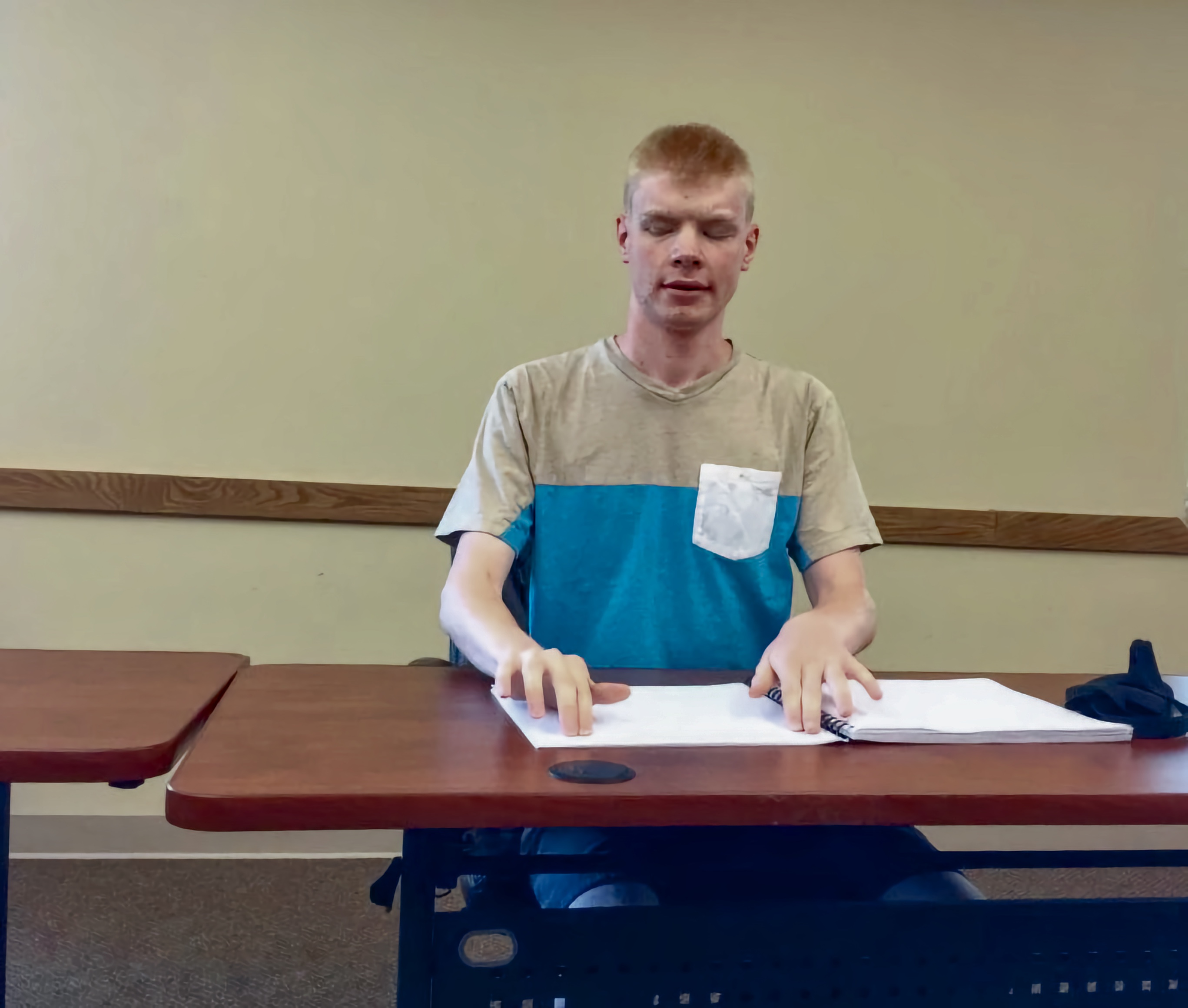 Luther Fuller of Kansas reads Braille before leaving for the National Braille Challenge