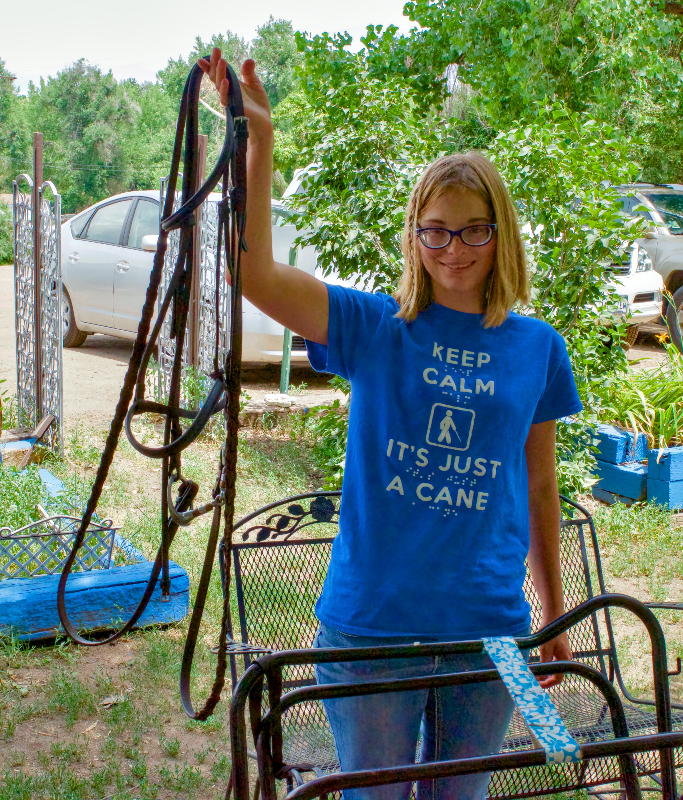 Marie holds up a bridle which she took apart, cleaned and re-assembled complete with bit