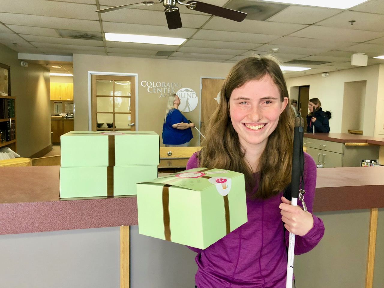 Rebecca beams as she holds up a box of her Birthday cupcakes