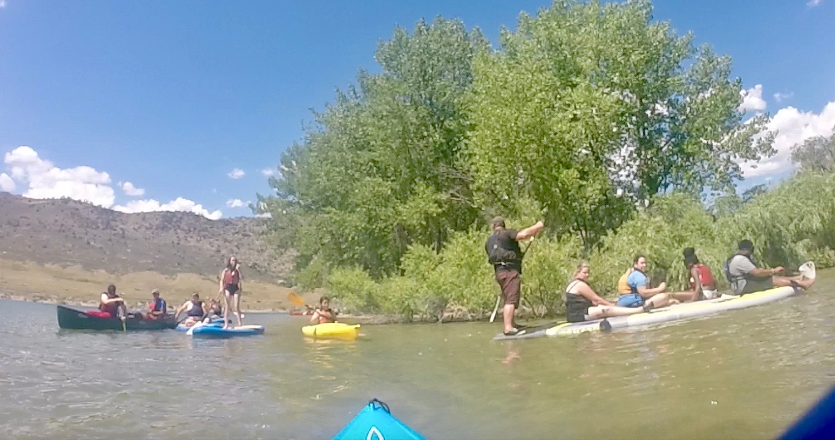 A large group of CCB Summer Youth on Paddle Boards, Kayaks and Canoes