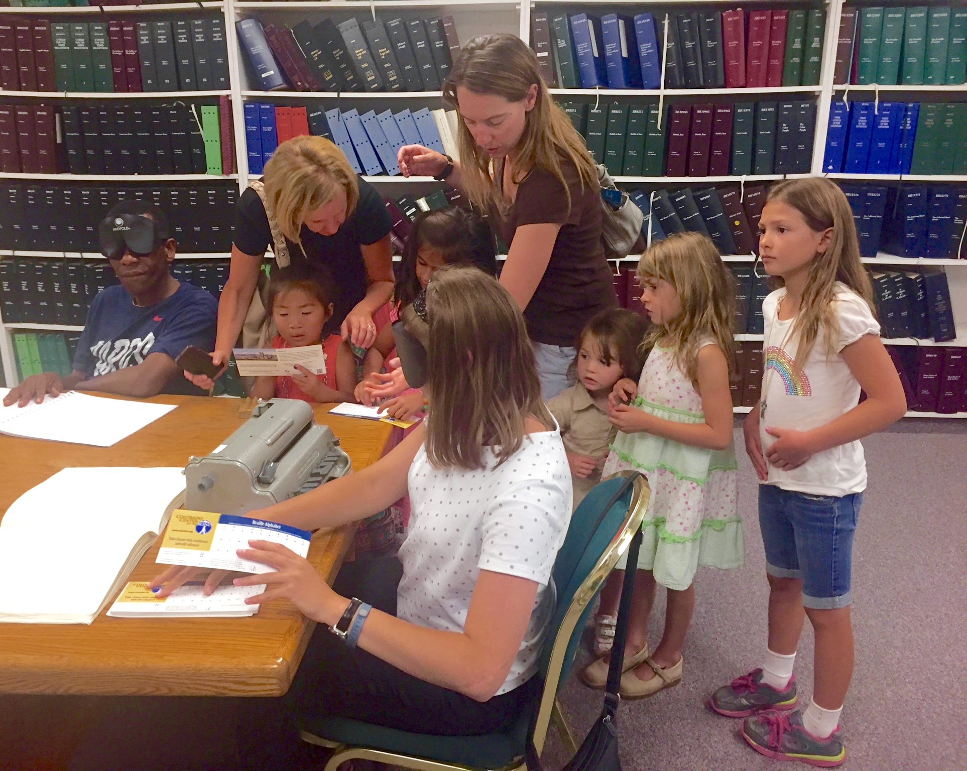 Shelby hands out Braille cards to a group of very interested children