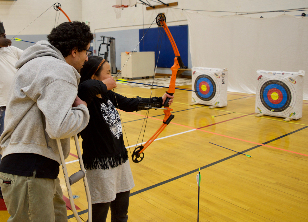 Suzi takes aim with her bow in Archery Class