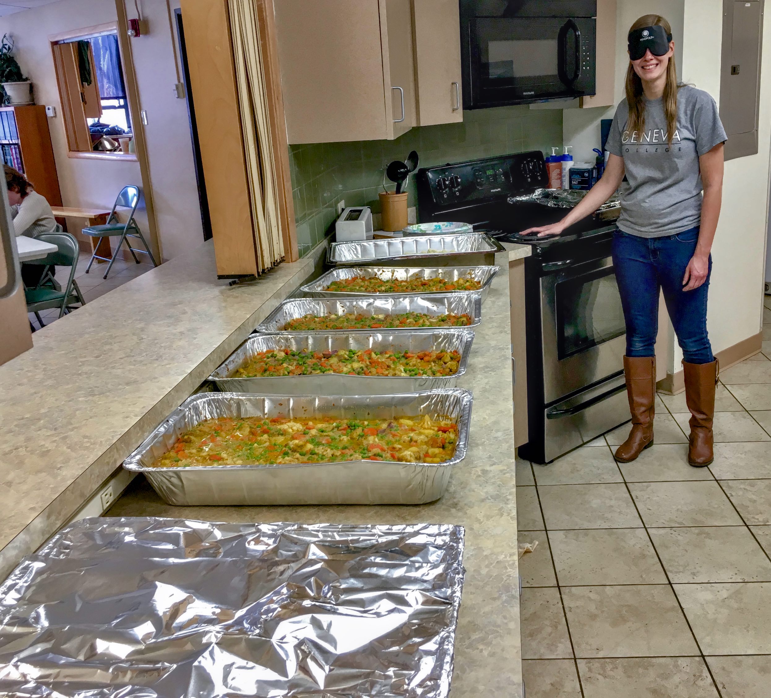 Tabea stands at the end of a long row of food ready to searve at her grad meal