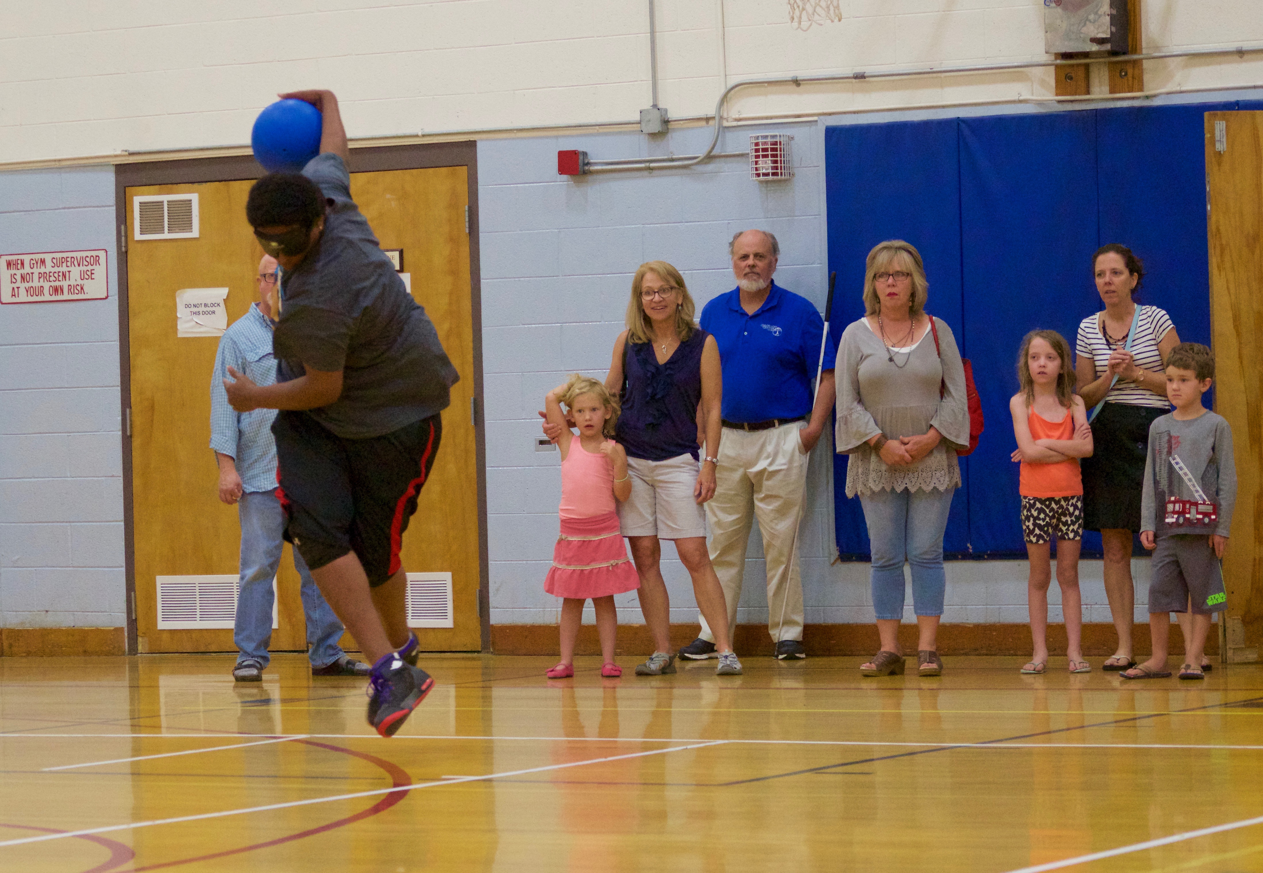 a young man releases the ball waist-high at the end of his spin, his feet off