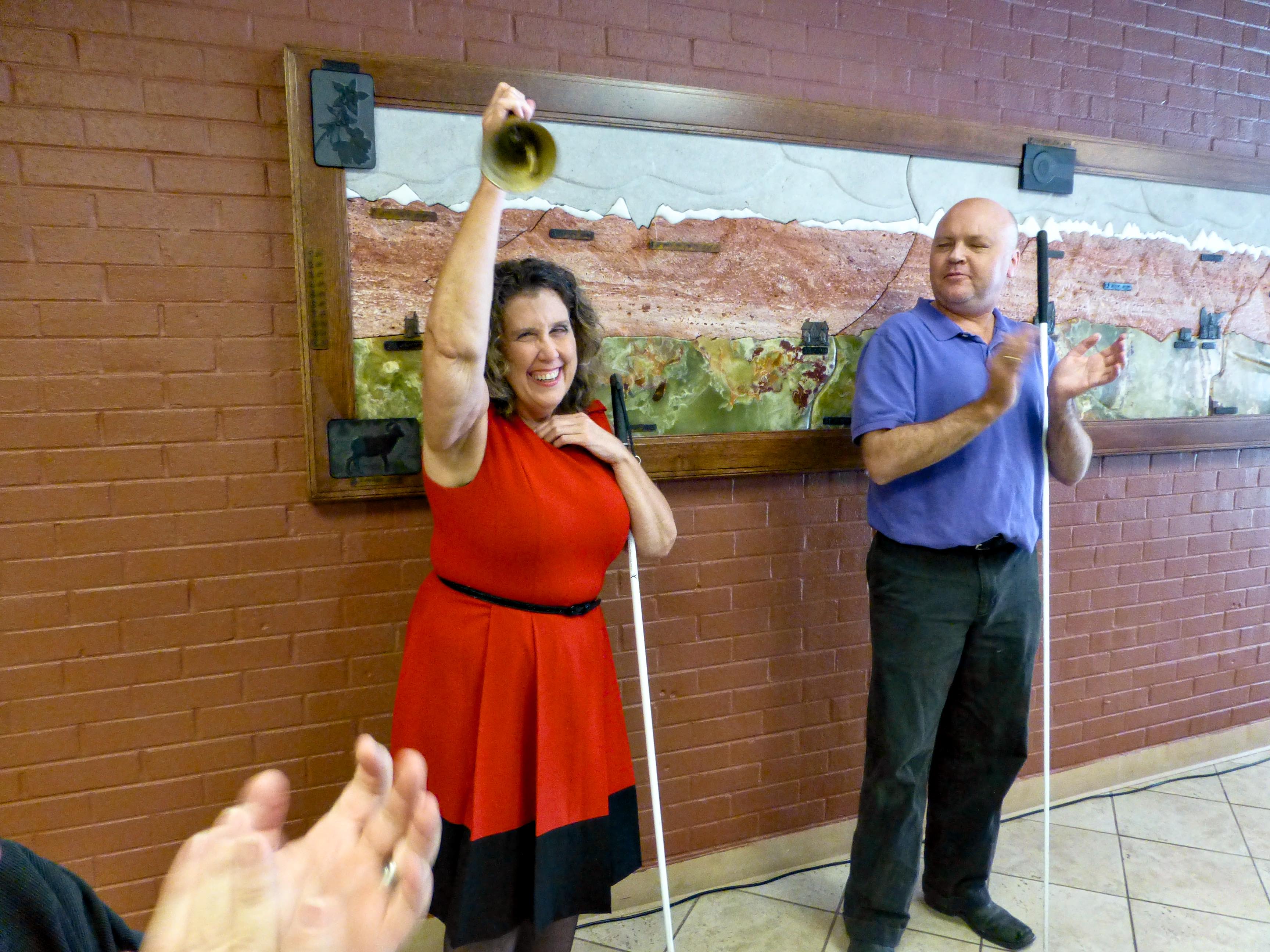 A woman gives her Freedom Bell a vigorous ring