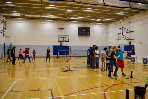 A group of Martial Arts Students to the left and a row of Archery Students to the right