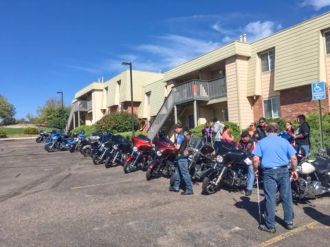 Students and staff near motorcycles lined up in front of McGeorge Mountain Terrace Apartments