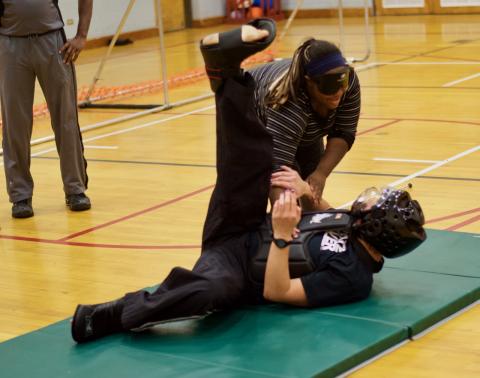 Brittany throws Travis flat on his back on the mats