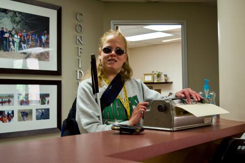 C.G. signing in at the lobby Brailler with a smile