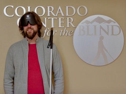 Graham standing in front of the CCB logo in the front lobby
