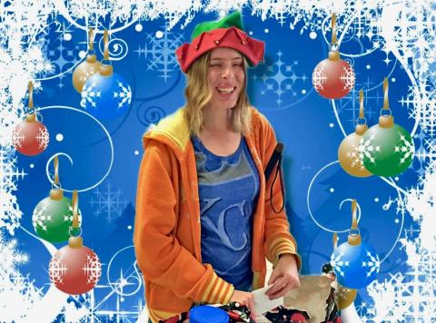 Holly wearing a festive elf hat and passing out gifts.