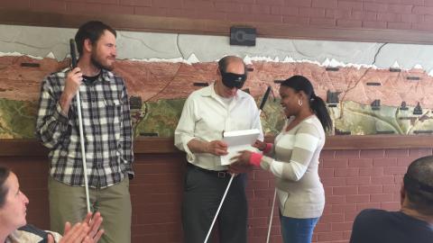two instructors award the bell to the student