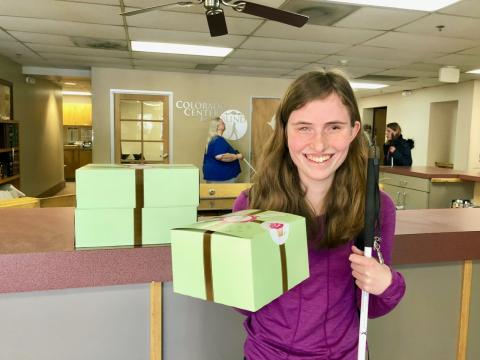 Rebecca beams as she holds up a box of her Birthday cupcakes