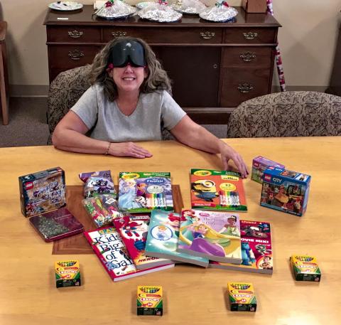 A smiling woman displays items she is about to deliver