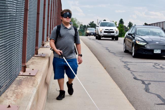 Andres hurries along a busy street to get to the light rail station