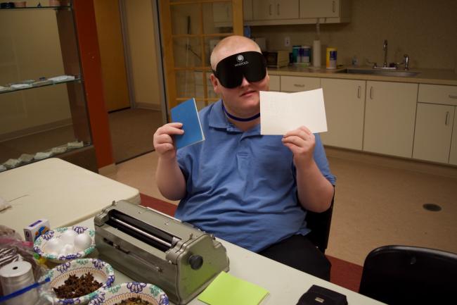 Michael holds up a couple of Braille Christmas Cards he made