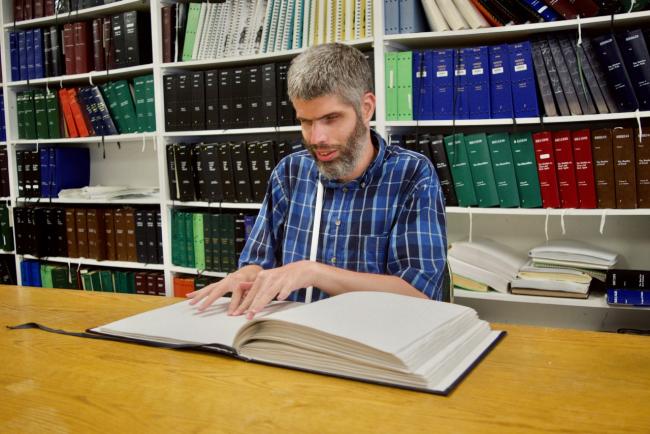 Russel reading a Braille book