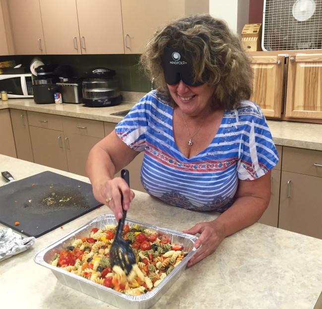 Vicki in the Large Kitchen preparing a colorful pasta salad