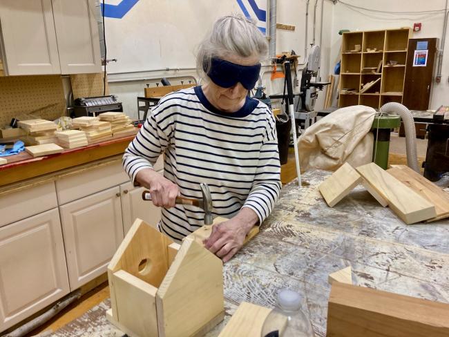 One of the In Charge students hammers a nail into the roof of a nearly completed bird house