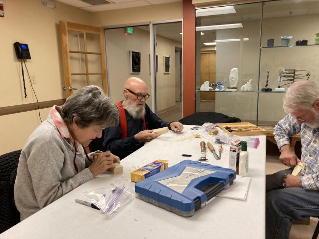 Ron (right) instructs Mary Jo and Christie (left) in wood carving - they made pinewood derby cars