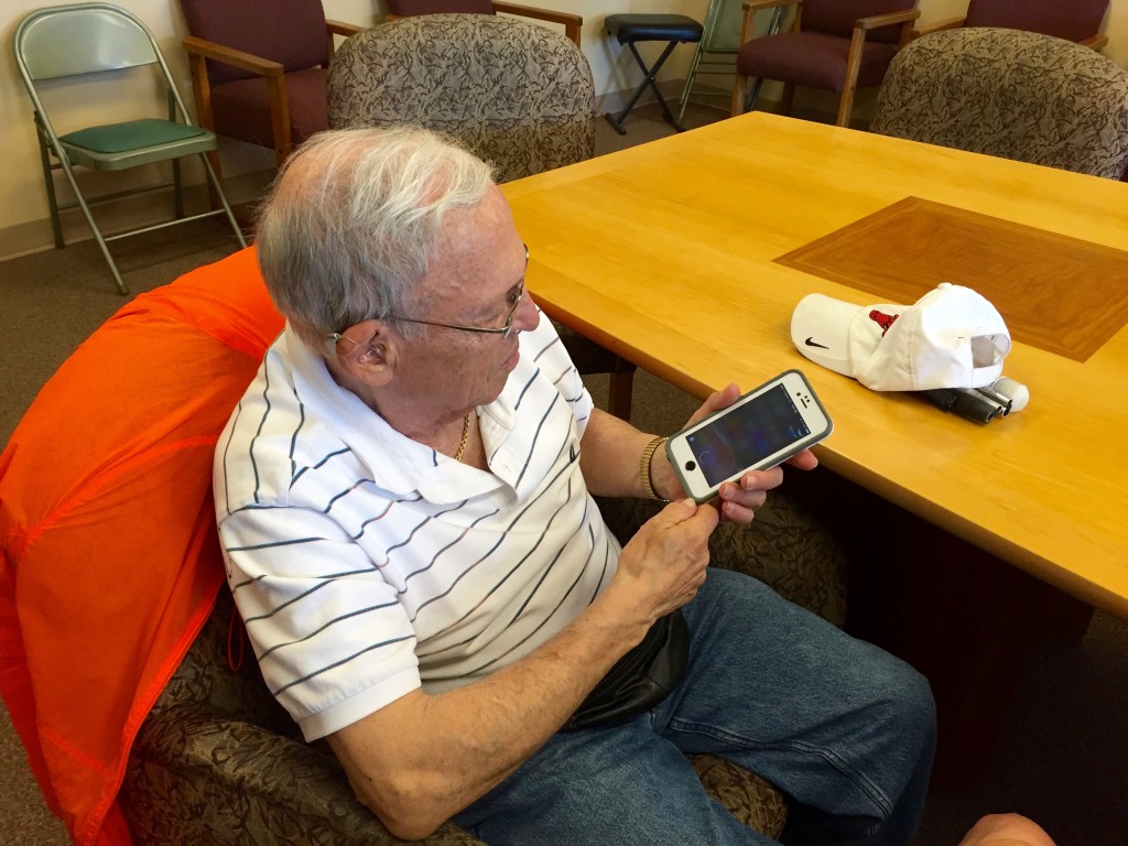 Senior Using an iPhone for Taking Notes