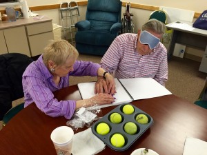 A senior woman and man explore a Braille cell with touch