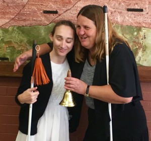 Julie and Haylee hug and smile broadly as the Freedom Bell is presented