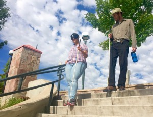 Dramatic view looking up at Poonam and David coming down the main steps at Littleton Downtown Station