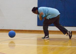 Young man demonstrates a spin throw in Goalball