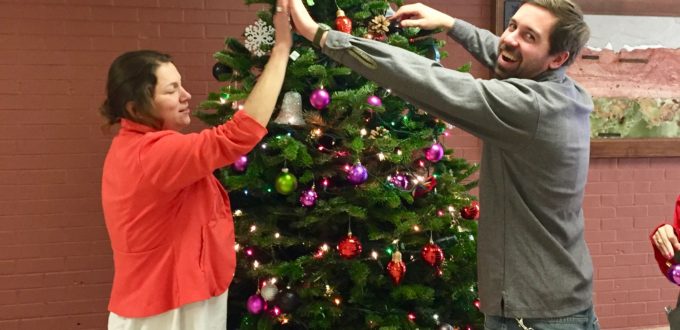Chris K. and Delfina high fiving in front of the tree