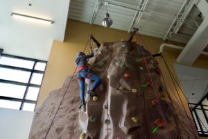 Danielle rings the bell at the top of the climbing wall
