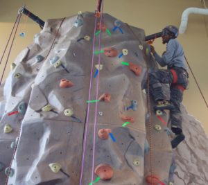 Leon reaches the top of the climbing wall and sports a huge grin