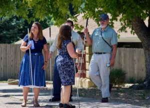 Julie, Chris P., Brent and Dan stand under a tree in the eclipse pinhole shadows
