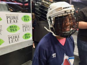 Ravi flashes a huge smile from inside her hockey helmet and mask