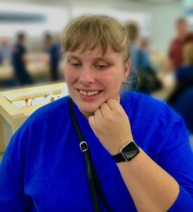 Grinning, Megan shows the Apple watch on her wrist to the camera