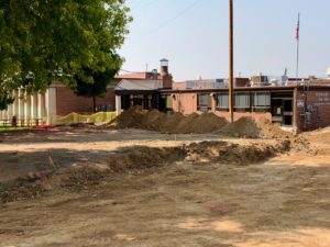 A view of the torn up parking lot in front of the Colorado Center for the blind with excavation trenches and tall mounds of dirt