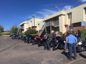 CCB students and staff gather near a row of motorcycles lined up in front of the McGeorge Mountain Terrace Apartments