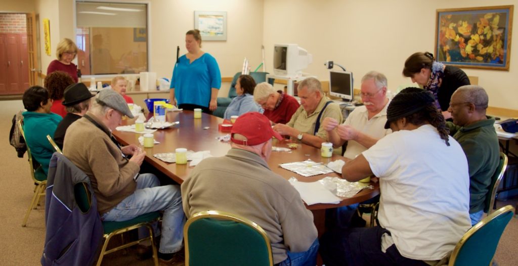 A group of a dozen seniors along with CCB staff work on making sugar scrub