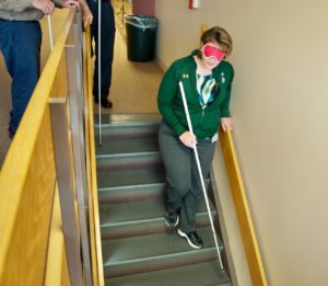 Christie going down the stairs for the 1st time with a cane and wearing sleepshades