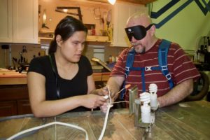 Stephannie and Mark work together using a color identifier to match the correct wire colors to re-wire a light fixture in Home Maintenance Class
