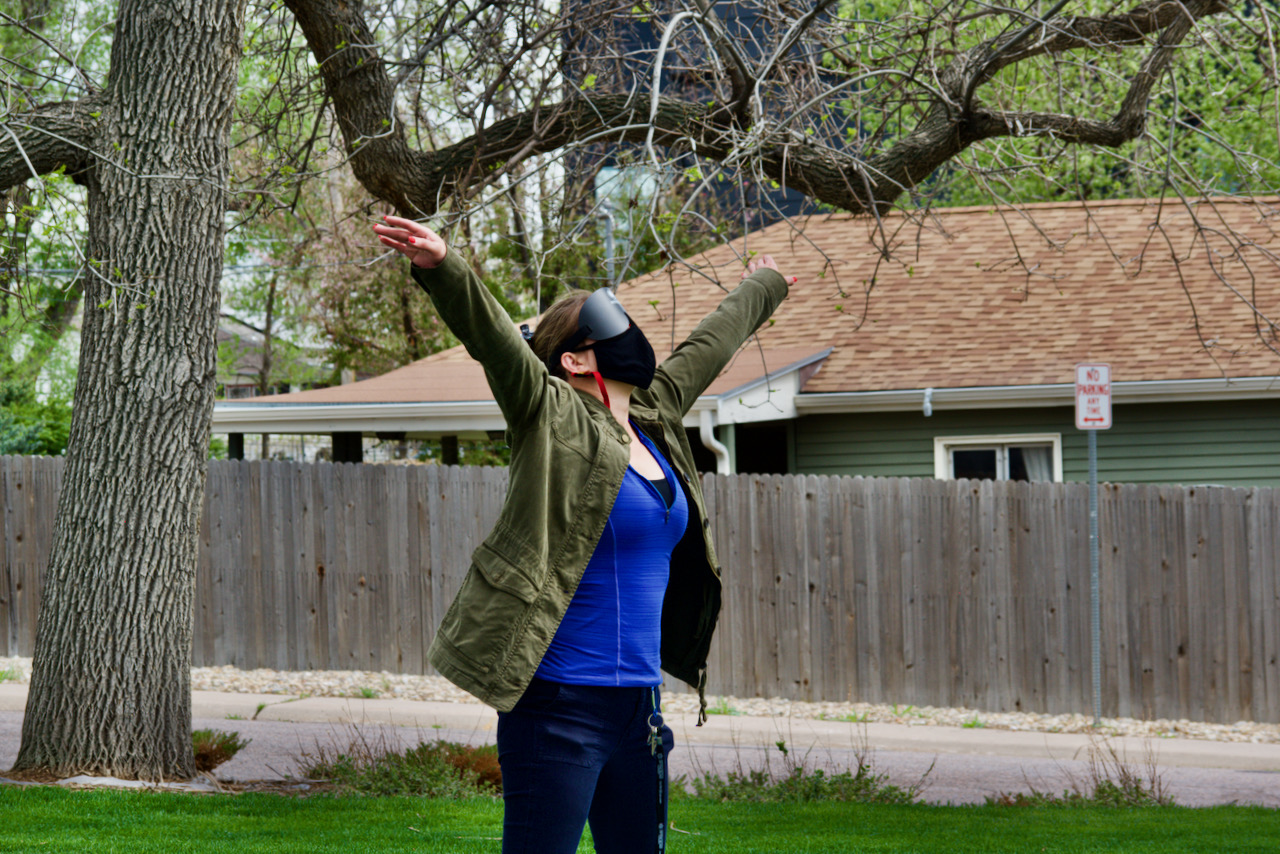 Leilani under the locust tree reaches arms to the sky during yoga on the lawn