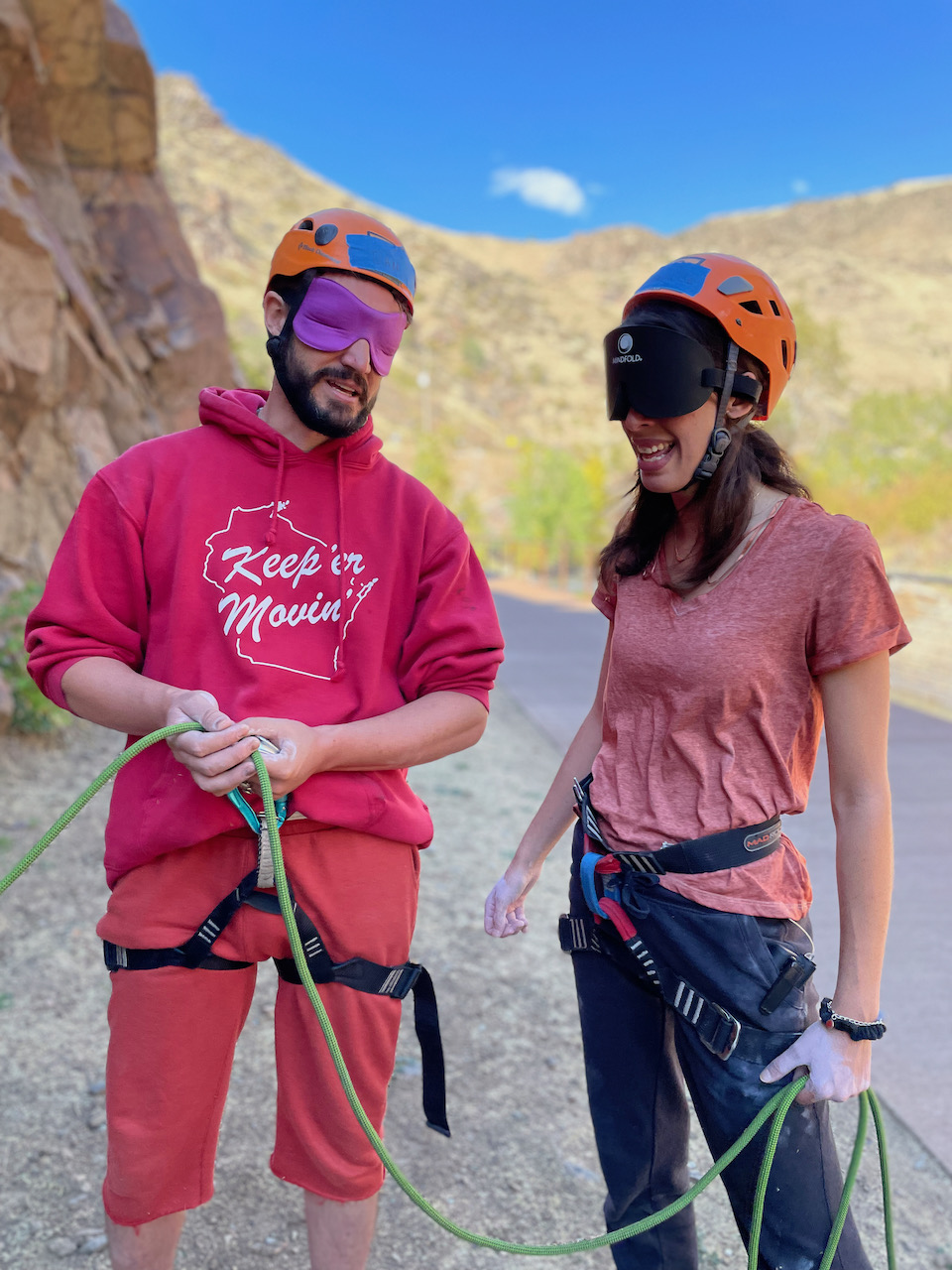Dan H (left) and Annalise (right) grin as they hold the rope and prepare to belay another student climber.