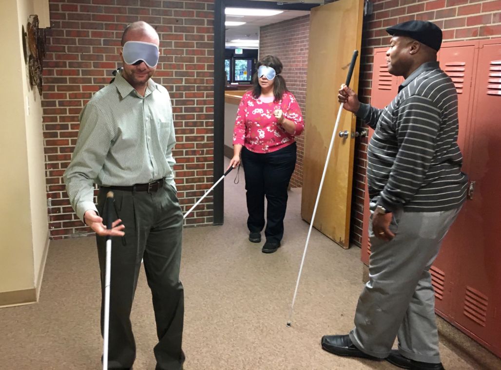 Wayne with 2 Wyoming IL folks in trave walking from the front lobby through the door past the lockers