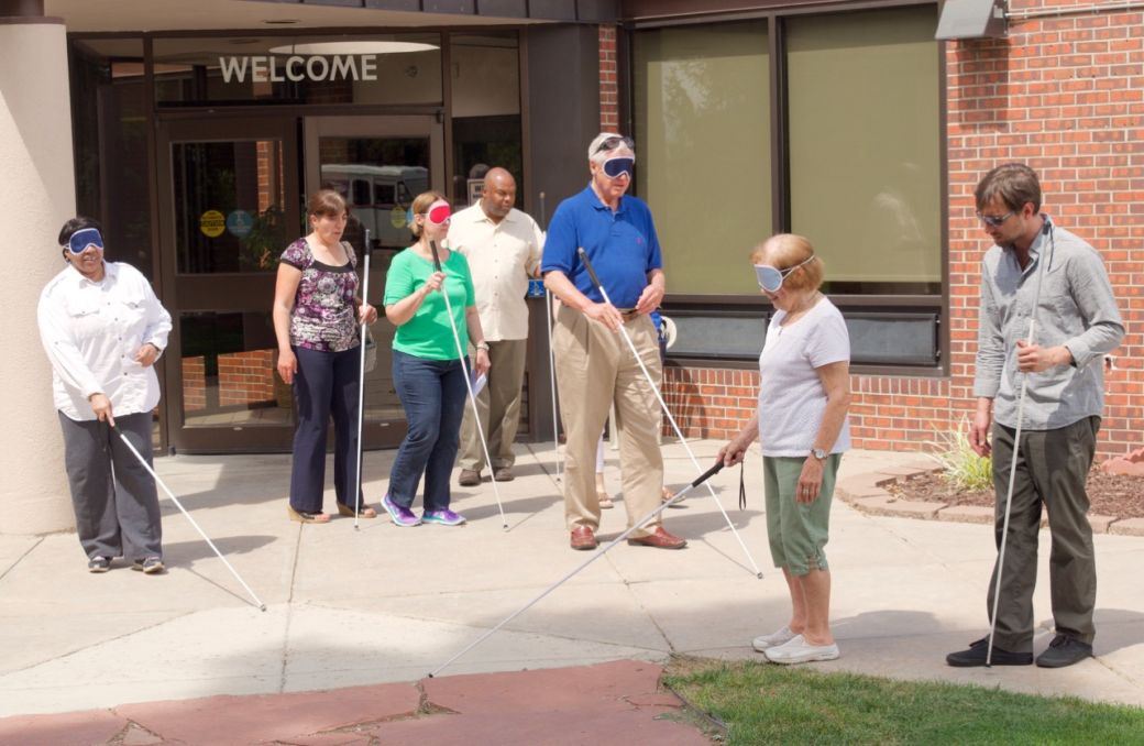 seven people go out the front door with white canes