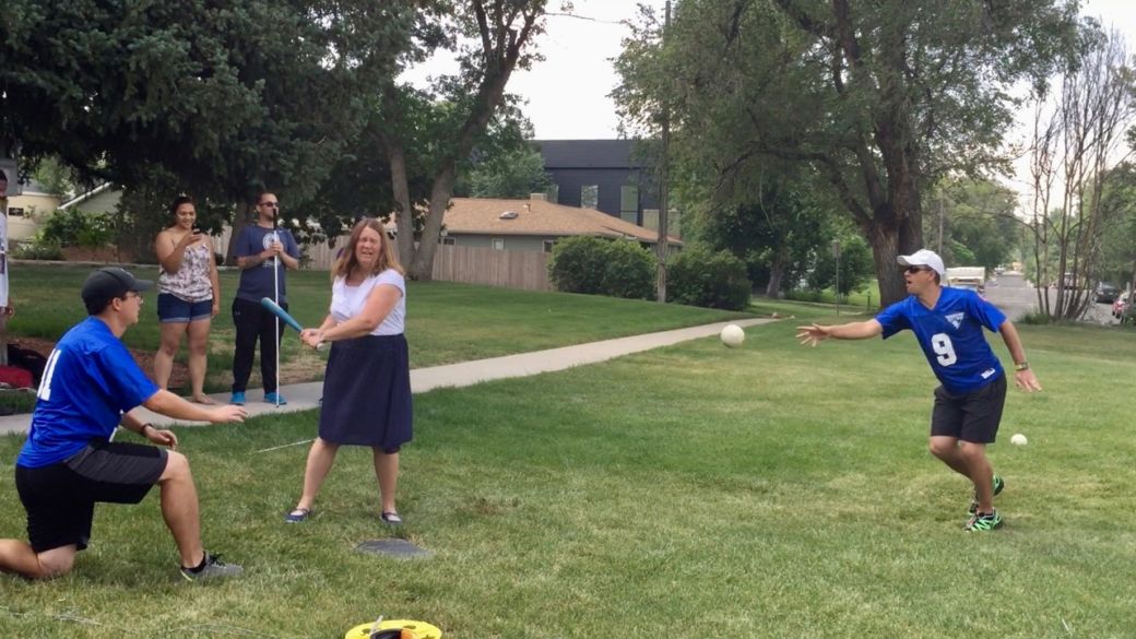 Julie at bat with the ball in mid air after the pitch