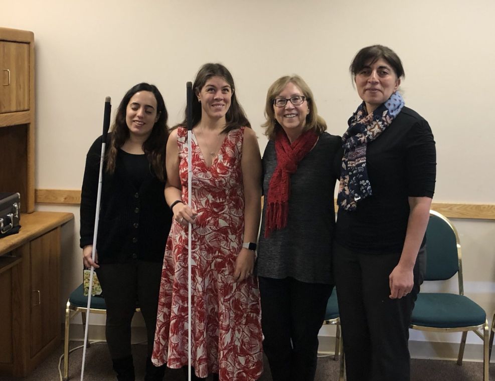 Four smiling women stand together in the Senior Resource Room