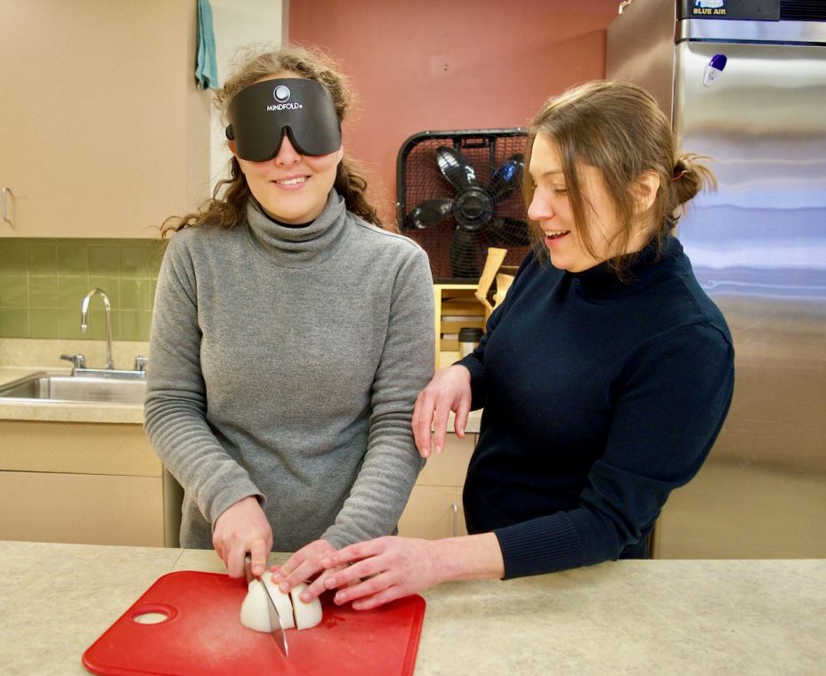 female student how to hold the knife as she slices an onion